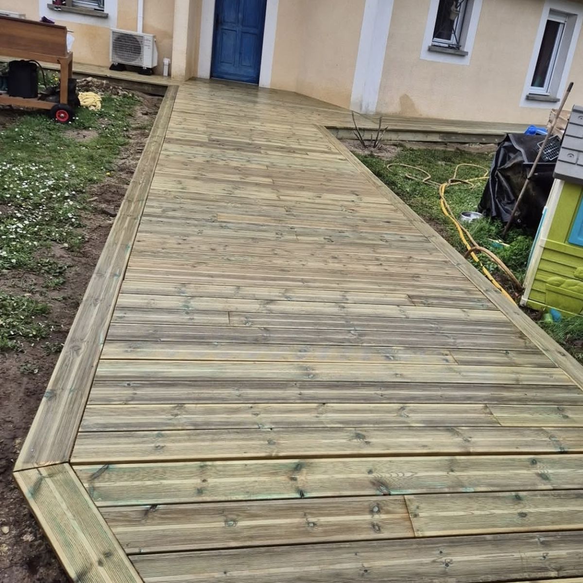 Allée en lames de bois jusqu'à la porte d'entrée