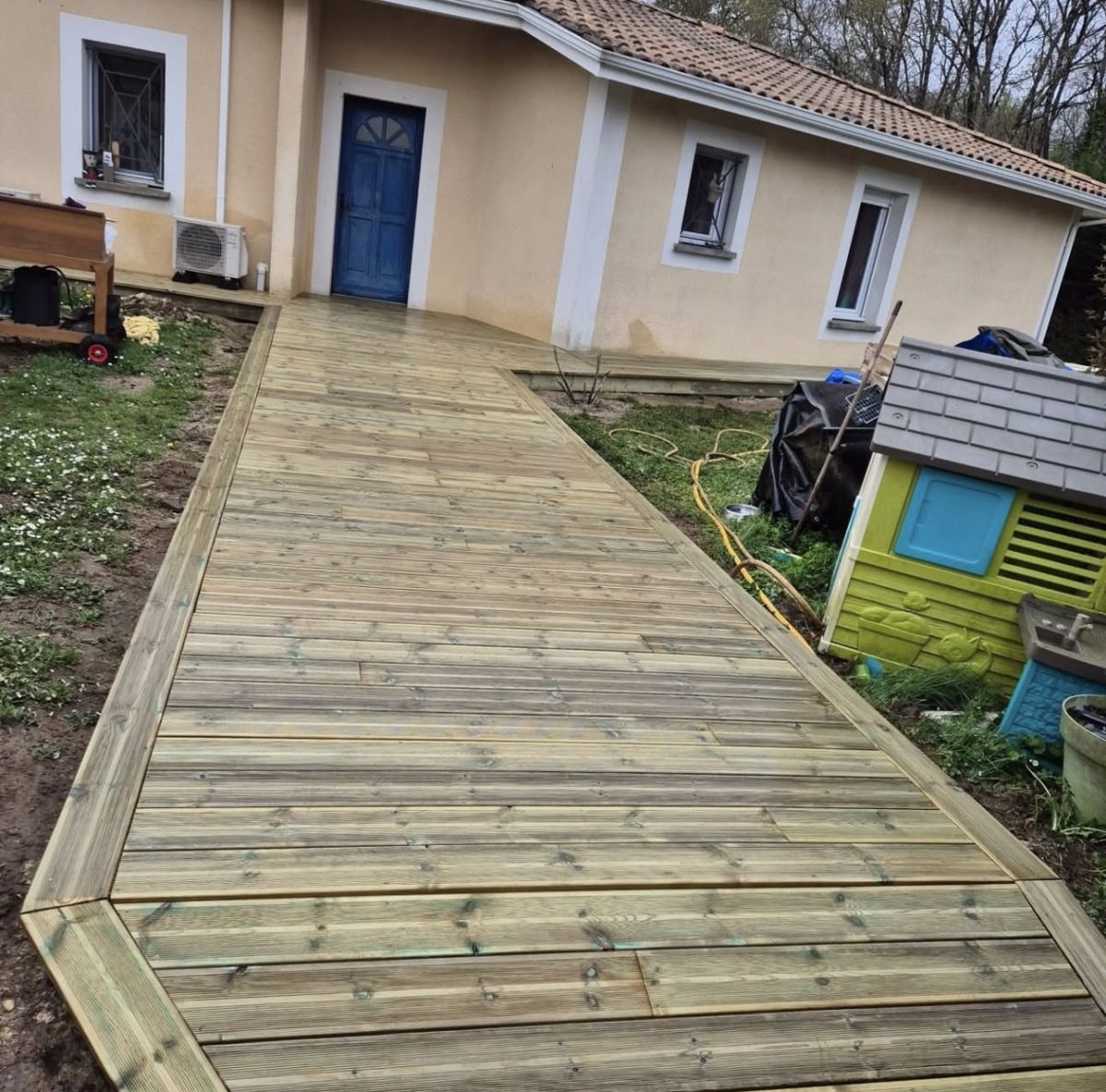 Allée en lames de bois devant une maison