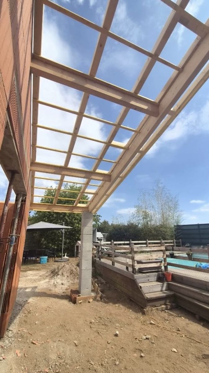 Ossature de pergola en bois contre une maison