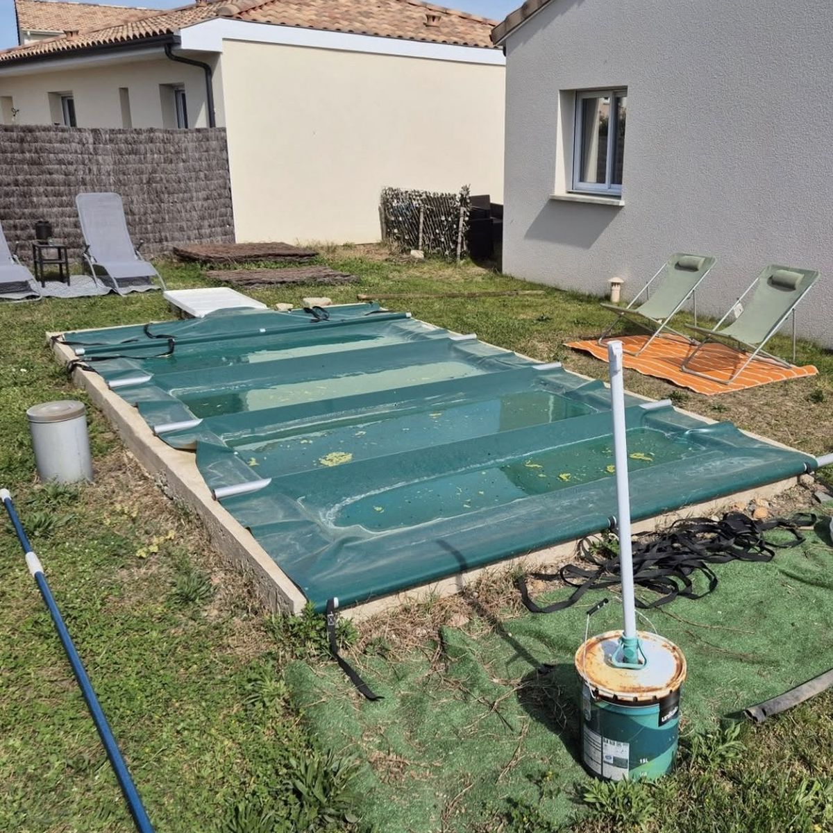 Jardin avant travaux, piscine bâchée posée dans l'herbe